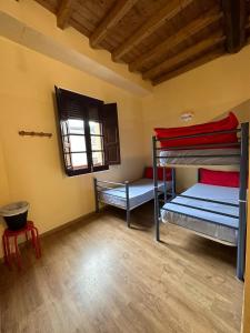 Habitación con literas en una habitación con ventana en Albergue de peregrinos Compostela, en Molinaseca