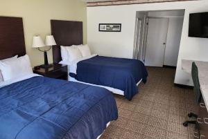 ステートカレッジにあるNittany Budget Motelのベッド2台とテレビが備わるホテルルームです。