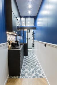 a kitchen with blue walls and a stove top oven at Le Café des Invalides in Paris