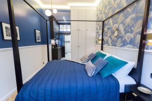 a blue bedroom with a large bed with pillows at Le Café des Invalides in Paris