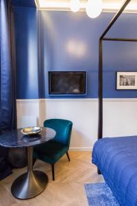巴黎的住宿－Le Café des Invalides，一间卧室配有桌子、床和电视。