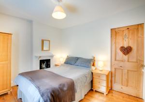 a bedroom with a bed and a wooden door at Ty Newydd in Dolgellau