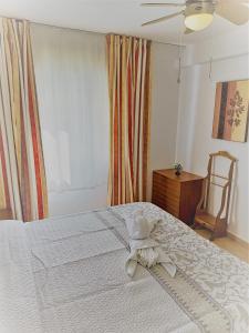 Un dormitorio con una cama blanca con una toalla. en Mayca - Beach and city, en Torremolinos