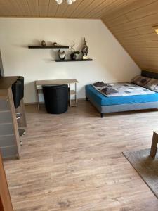 雷馬根的住宿－Ferienwohnung Kristof，一间卧室配有一张床,铺有木地板