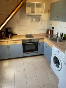 雷馬根的住宿－Ferienwohnung Kristof，厨房配有洗衣机、水槽和洗衣机。