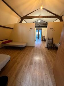モリナセカにあるAlbergue de peregrinos Compostelaのソファ付きの広い客室で、床はウッドフロアです。