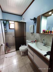 a bathroom with a toilet and a sink and a shower at Quarto, piscina e acesso exclusivo in Encantado