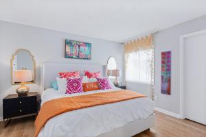 1 dormitorio con 1 cama grande y almohadas coloridas en The Sanddollar Castle en St. Augustine