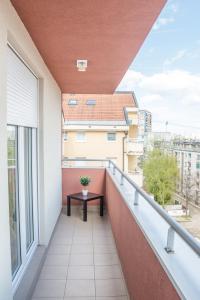 uma varanda com uma mesa e uma vista em Apartment Simpatico em Novi Sad