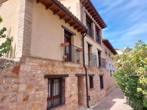 un antiguo edificio de piedra con balcones en una calle en La Cocineta - Zaracatralla, en Alquézar