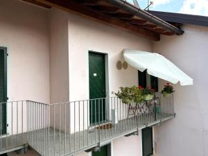 - un bâtiment blanc doté d'un balcon avec une porte verte dans l'établissement Il Nido, à Castelletto sopra Ticino