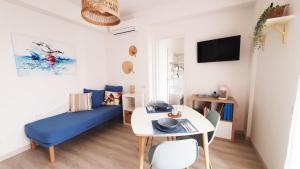 ein Wohnzimmer mit einem blauen Sofa und einem Tisch in der Unterkunft NUMANA SEA APARTMENT in Numana