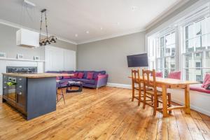 eine Küche und ein Wohnzimmer mit einem Tisch und Stühlen in der Unterkunft Market Street Apartment Sleeps 6 in St Andrews