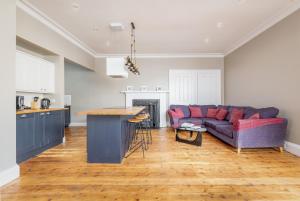 ein Wohnzimmer mit einem Sofa und einem Tisch in der Unterkunft Market Street Apartment Sleeps 6 in St Andrews