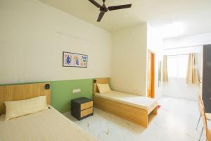 um quarto com 2 camas e uma ventoinha de tecto em Covie Bannergatta 185 em Bangalore