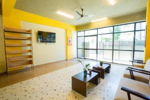 uma sala de estar com paredes amarelas e um sofá e uma mesa em Covie Bannergatta 185 em Bangalore