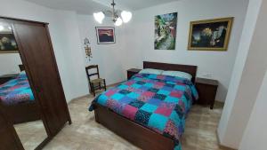 1 dormitorio con 1 cama y 1 silla en La Cocineta - Zaracatralla, en Alquézar