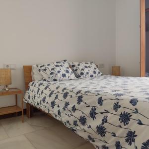 1 dormitorio con 1 cama con edredón azul y blanco en Casa de la escalera 1ª D, en Córdoba