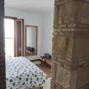 1 dormitorio con cama y pared de piedra en Casa de la escalera 1ª D, en Córdoba