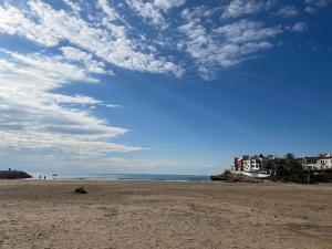 une plage de sable avec un ciel bleu et des nuages dans l'établissement La Brisa Marina, à Roda de Bará