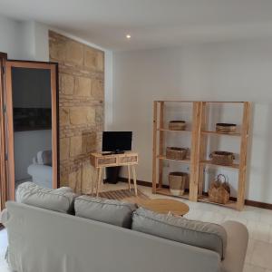 a living room with a couch and a desk with a computer at Casa de la escalera 1ª D in Córdoba