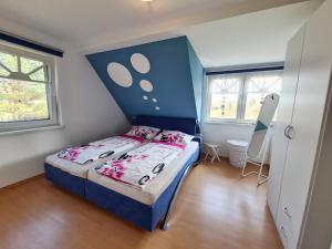 a small bedroom with a bed with a blue headboard at Ferienwohnung Lisa in Barth