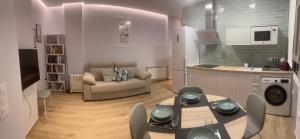 a kitchen and a living room with a table and a couch at Apartamento Centro León GVSM in León +41 photos