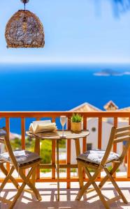 a table and two chairs on a balcony with a table and a wine glass at Villa Blue, LaVanta, Kalkan in Kalkan