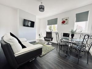 uma sala de estar com um sofá branco e uma mesa em Spacious House 4 Bedrooms, 2 Bathrooms - Short & Long Stays, Contractors - Leisure em Derby