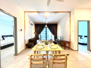 a dining room and living room with a table and chairs at Golden House-Atlantis Residence in Malacca