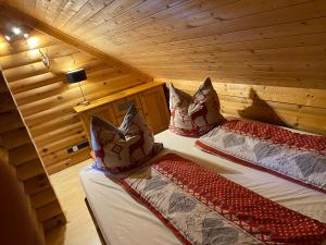 Un dormitorio con dos camas en una cabaña de madera. en Blockhaus Rennsteig, en Neuhaus am Rennweg