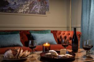 uma sala de estar com um sofá e uma mesa com copos de vinho em My Boudoir em Paris
