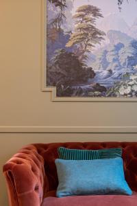 una pintura en la pared sobre un sofá con una almohada en My Boudoir en París