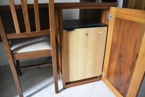 a wooden cupboard with a chair next to a door at Hotel Aquila in Scoppito
