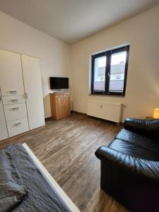 - un salon avec un canapé et une télévision dans l'établissement Monteurzimmer in Bielefeld - Mitte, à Bielefeld