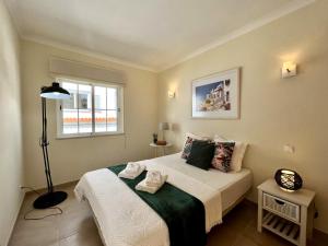 a bedroom with a bed and a window at Carvoeiro Terrace by Homing in Carvoeiro