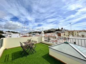a balcony with a table and chairs on a roof at Carvoeiro Terrace by Homing in Carvoeiro