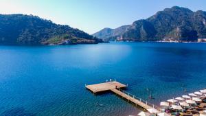 uma praia com guarda-sóis e uma doca na água em Orka Lotus Beach em Marmaris