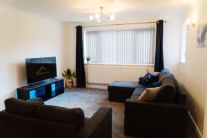 a living room with two couches and a television at Solihull 5 Bed Home near NEC/Bham airport/JLR/HS2 in Solihull