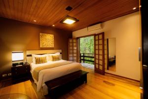 a bedroom with a large bed and a window at Pousada Apple House - Campos do Jordao in Campos do Jordão