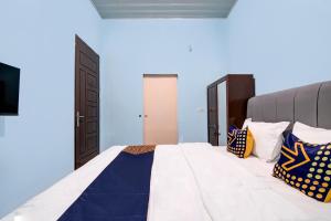 1 dormitorio con 1 cama grande y paredes azules en SPOT ON 92493 Pondok Mulia Syariah en Pekanbaru