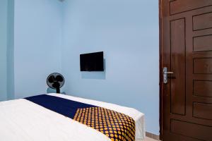 a bedroom with a bed and a blue wall at SPOT ON 92493 Pondok Mulia Syariah in Pekanbaru