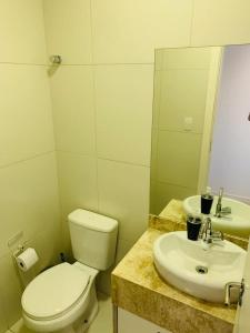 a bathroom with a toilet and a sink at Reserva Eco Itacimirim in Camaçari