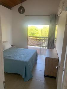 um quarto com uma cama azul e uma varanda em Reserva Eco Itacimirim em Camaçari