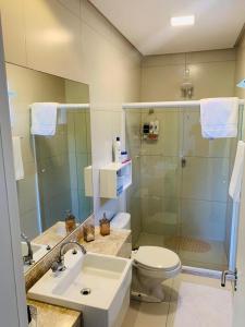 a bathroom with a toilet and a sink and a shower at Reserva Eco Itacimirim in Camaçari