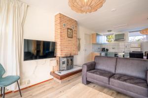 a living room with a couch and a fireplace at Parel 164 in Den Burg