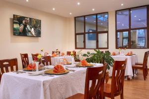 uma sala de jantar com mesas e cadeiras com toalhas de mesa brancas em West Lerruat Hotel em Nairobi