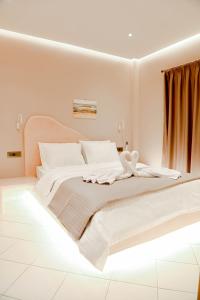 biała sypialnia z dużym łóżkiem z białą pościelą w obiekcie THE ROCK LUXURY HOMES w mieście Mesaria