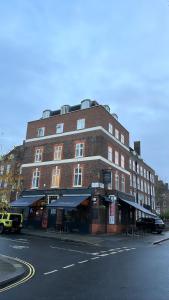 un grand bâtiment en briques au coin d'une rue dans l'établissement Three Falcons, à Londres