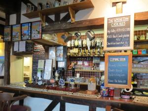 a bar in a restaurant with a counter with alcohol at The Wyche Inn in Great Malvern